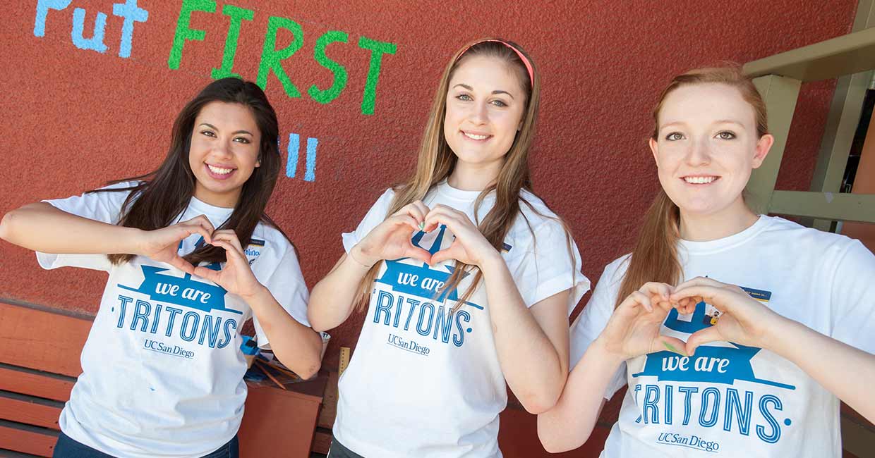 3 Girls holding up heart signs with hands